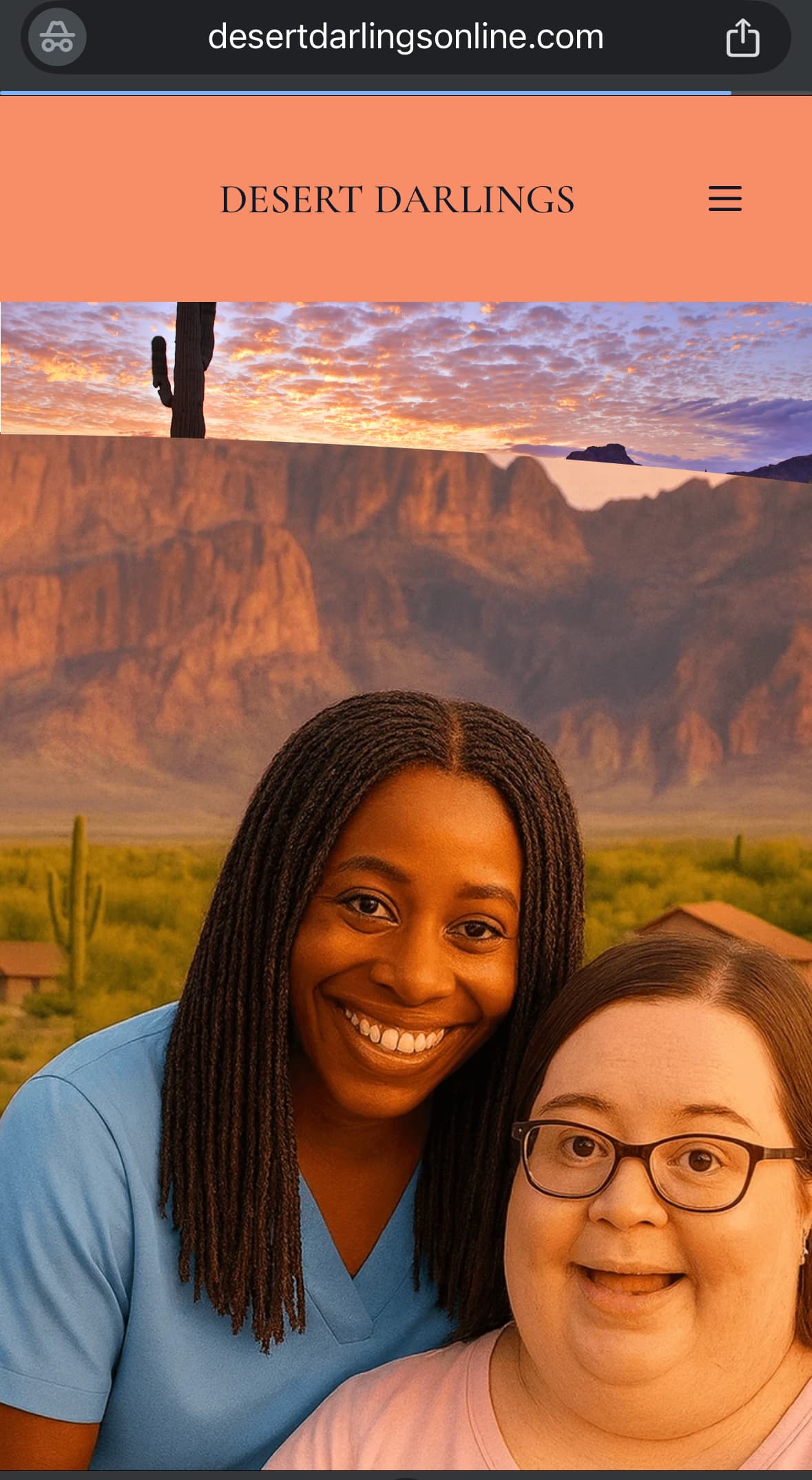 Two women smiling together against a scenic desert mountain backdrop during a colorful sunset.